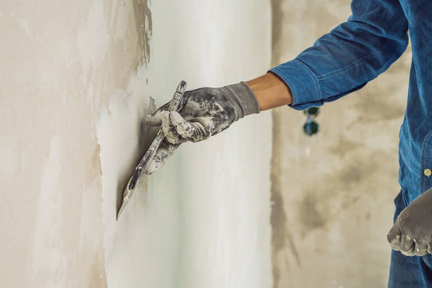 Hand of master applying white putty on wall. - Photo, Image
