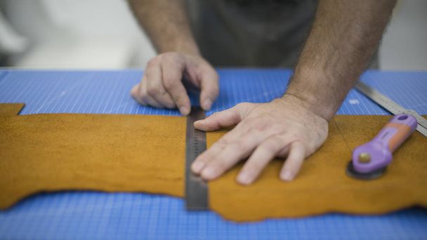 Les mains du maître. Marquage cuir pour la fabrication de sacs, sacs à main ou chaussures
. - Photo, image