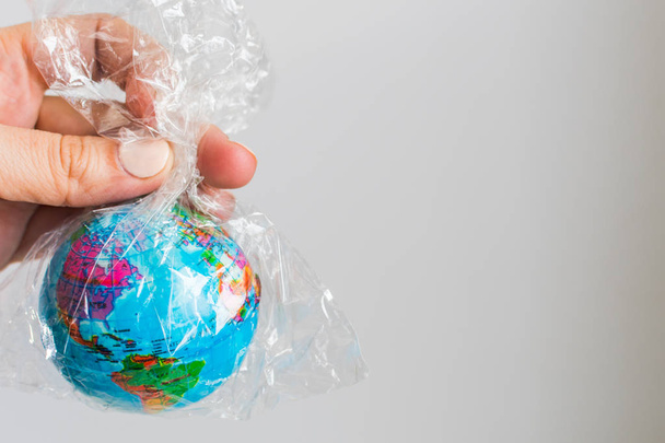 pequeño globo de tierra en una bolsa de plástico. El concepto de la Tierra pura
 - Foto, imagen