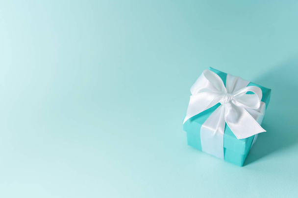 blue color box tied with silk ribbon on pastel blue background  - Foto, Imagem