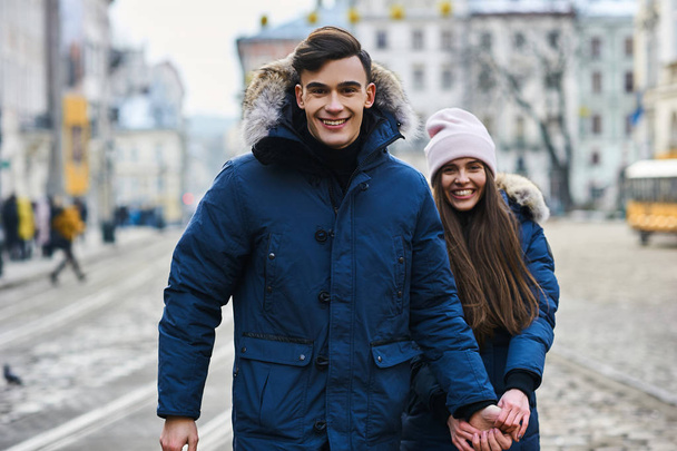 Una pareja de jóvenes de moda pasea por la ciudad en Navidad - Foto, imagen