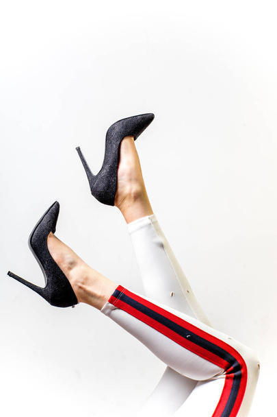 Naisten jalat valkoisissa housuissa ja kengissä
 - Valokuva, kuva