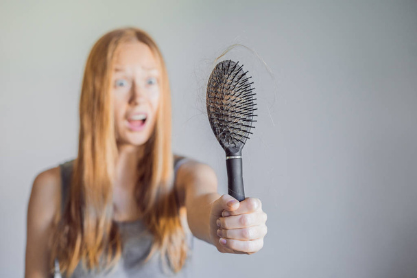 Hair loss in women concept. A lot of lost hair on the comb - Foto, imagen
