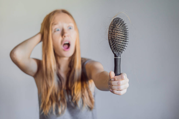 Hair loss in women concept. A lot of lost hair on the comb - 写真・画像