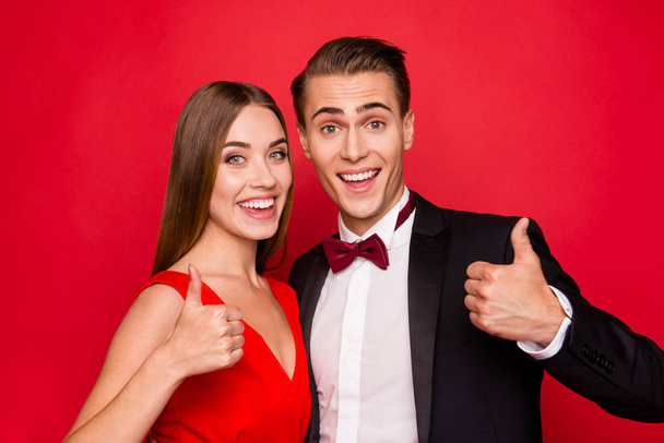 Portrait of two nice cool sweet lovely attractive gorgeous cheerful positive people married spouses showing thumbup advertising advert ad isolated over bright vivid shine red background - Φωτογραφία, εικόνα