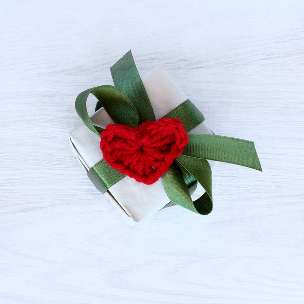 Holiday gift with green ribbon and red soft heart symbol top view / surprise in Day of Love - Foto, immagini