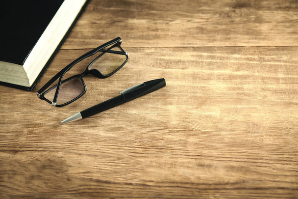 Könyv, szemüveg és toll a fa háttér.  - Fotó, kép