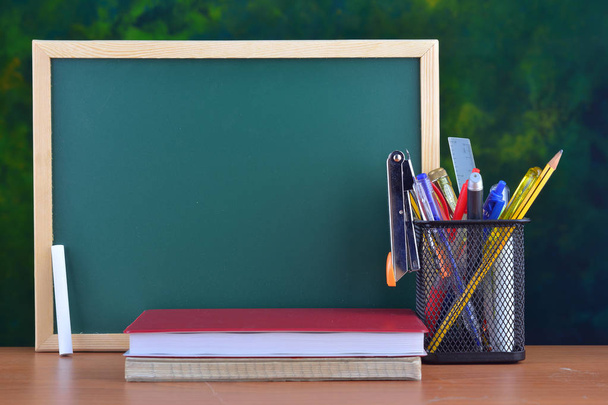 Back to School concept with stationery on table in front of chalkboard - Photo, Image