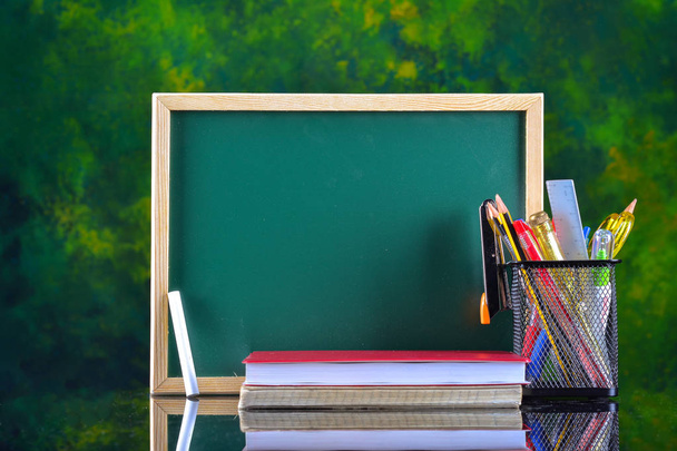 Powrót do koncepcji szkoły z papeterii na stole przed chalkboard - Zdjęcie, obraz