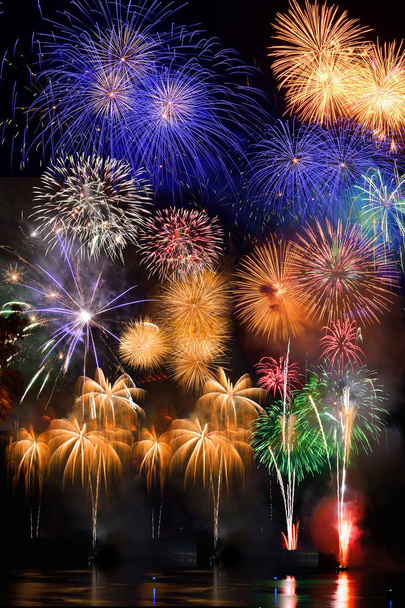 Colorful fireworks. Fireworks are a class of explosive pyrotechnic devices used for aesthetic and entertainment purposes. Visible noise due to low light, soft focus, shallow DOF, slight motion blur - Photo, Image