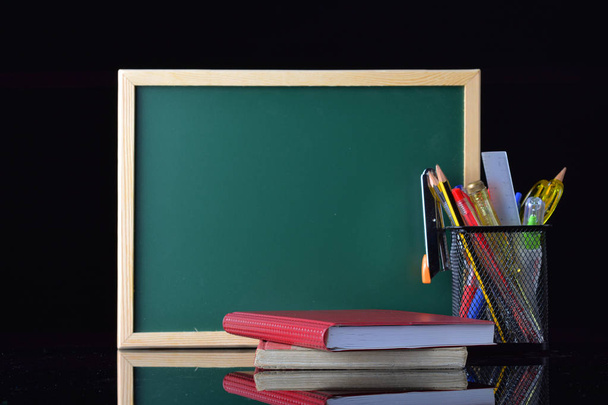 Back to School concept with stationery on table in front of chalkboard - Photo, Image