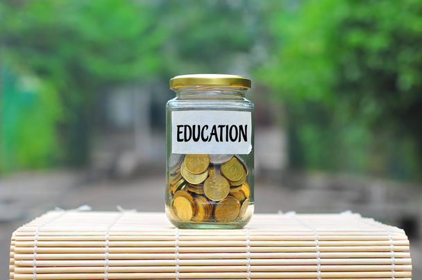 Coins in bottle with label Education - financial concept - Photo, Image
