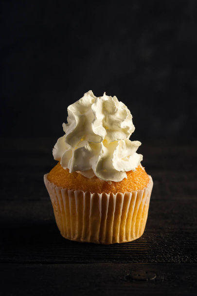 Whipped cream cupcake on a dark background - Фото, изображение