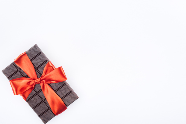 view from above of delicious chocolate wrapped by festive ribbon isolated on white, st valentine day concept - Foto, imagen