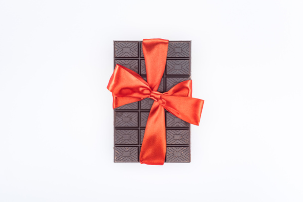 top view of delicious chocolate wrapped by festive ribbon isolated on white, st valentine day concept - Фото, изображение