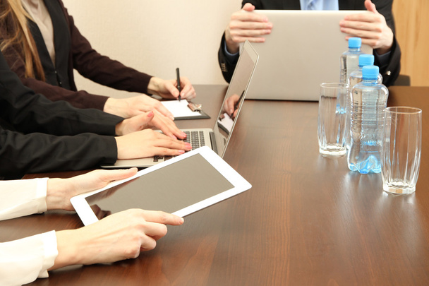 Mãos femininas com tablet digital no fundo do escritório. Foto conceitual da conferência de negócios
 - Foto, Imagem