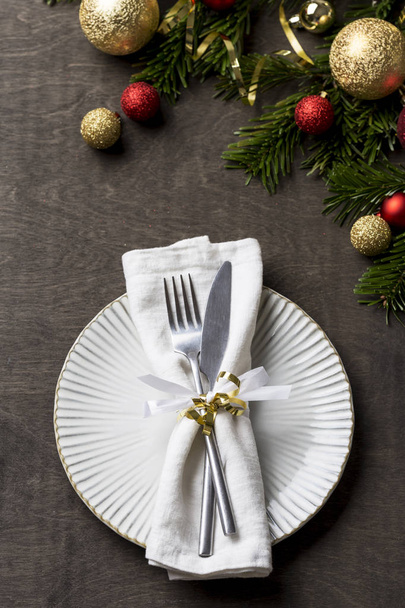 Рождественский стол с вилкой и ножом и рождественские праздничные украшения на белой тарелке
 - Фото, изображение