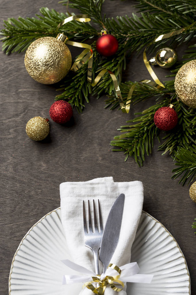 Świąteczne nakrycie stołu z widelcem i nożem i Boże Narodzenie Dekoracje świąteczne na białym talerzu. - Zdjęcie, obraz