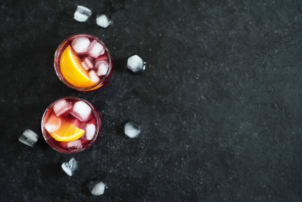Negroni Cocktail with orange and ice. Homemade Classic Negroni cocktail and ingredients on black background, copy space. - Foto, Imagen
