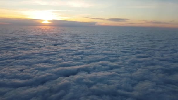 Letecký snímek načechraný mraky z okna letadla na nádherný západ slunce v létě působivé ptačí pohled bílé mraky plující dolů jako Bílého moře na nádherný západ slunce s zlatými paprsky z okna letadla v létě - Záběry, video