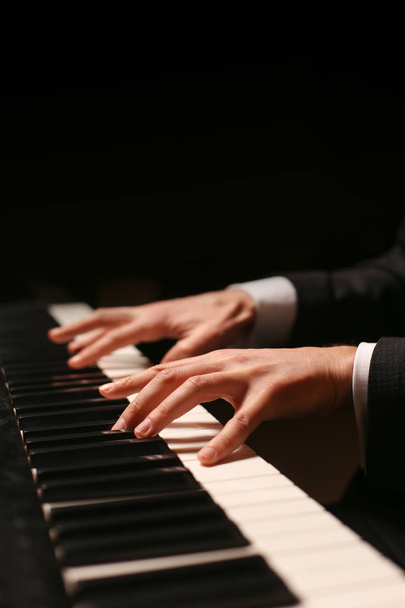Hands on piano. The pianist plays the piano. Piano keys on black background - Valokuva, kuva