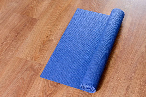 Blue yoga mat on wooden background - Photo, Image