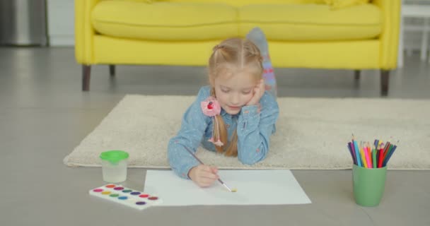 Little girl painting with paintbrush and paints - Felvétel, videó