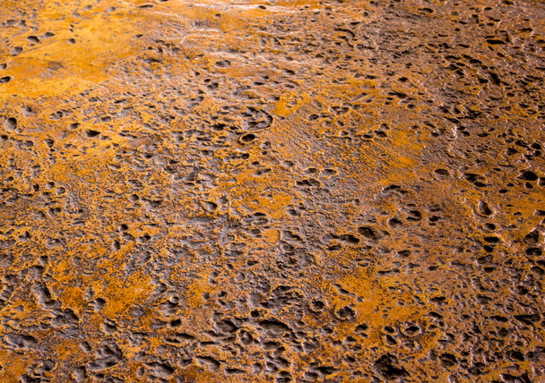 Muchos agujeros rugosos en el suelo de hormigón de color oxidado
 - Foto, imagen