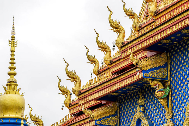 Όμορφο χρυσό άγαλμα βασιλιά του φιδιού στην κορυφή της Ταϊλάνδης ναό. Στην βουδιστική παραμύθια, θέλησε να γίνει μοναχός αλλά δεν μπορεί. Επειδή δεν είναι ανθρώπινο. - Φωτογραφία, εικόνα