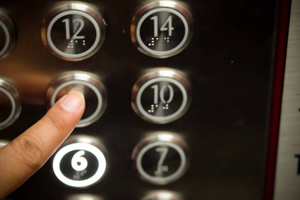 Close-up of pressing a touch button in a modern elevator. - Foto, Bild