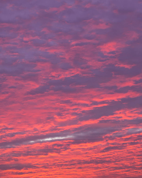 blauer, magenta und roter Himmel bei Sonnenuntergang mit dicken Wolken - Foto, Bild