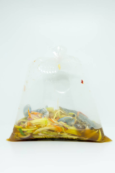 Salade de mangue épicée avec crabe bleu dans un sac en plastique, accent sélectif style thaï salade
 - Photo, image