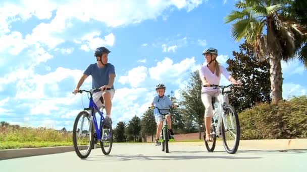 υγιή καυκάσιος οικογένεια ποδήλατο ιππασία μαζί - 映像、動画