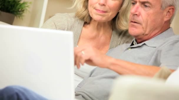 Las personas mayores que tienen éxito en línea en el ordenador portátil
 - Imágenes, Vídeo