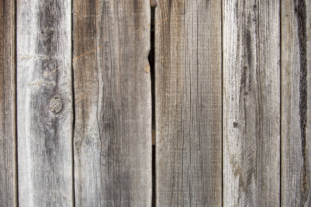 Közeli kép a természetes régi vintage viharvert szürke barna festetlen tömör fából készült kerítés vagy kapu táblák és a deszkák. Ökológiai textúra függőleges másol hely napos ropogott háttér. - Fotó, kép