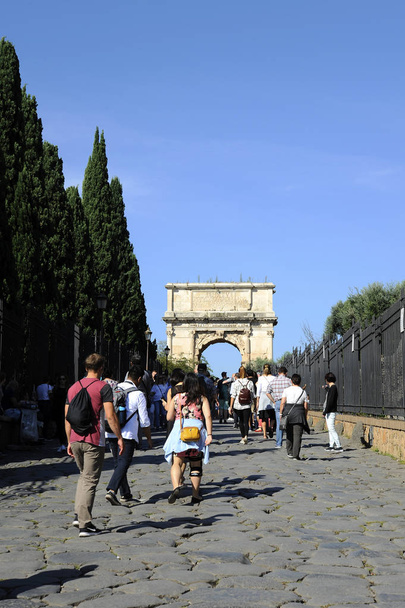 ROMA - 09 de octubre de 2018: Personas que entran en el Foro Romano a través de la Vía Sacra. Arco de Tito en el extremo opuesto
. - Foto, Imagen