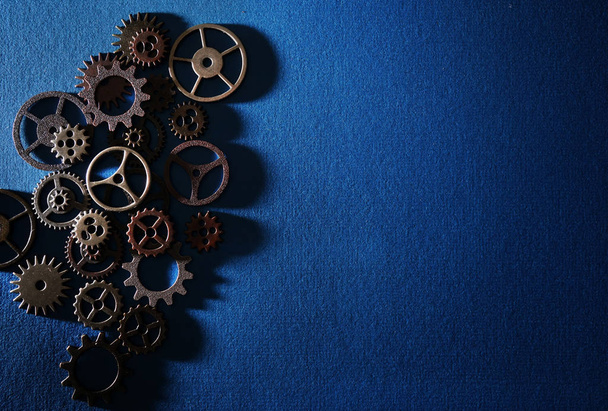 Assorted metal gears on textured blue background - Foto, Bild