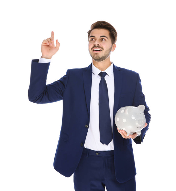 Young businessman with piggy bank on white background - Foto, imagen