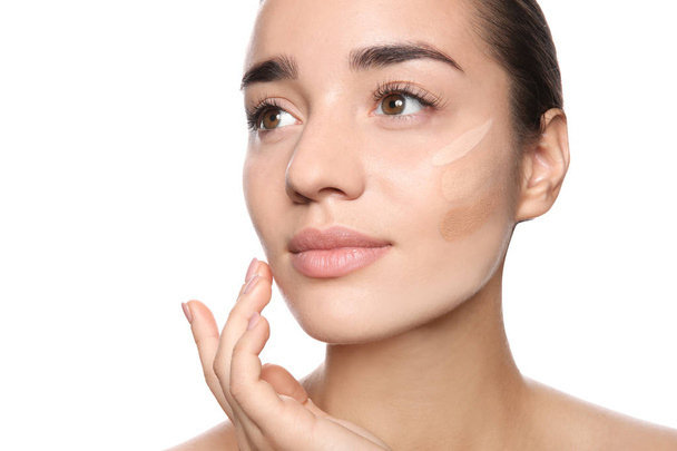 Young woman with different shades of skin foundation on her face against white background - Foto, imagen