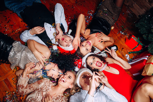 Group of friends at club having fun and lying on the floor .New years party - Foto, Imagen