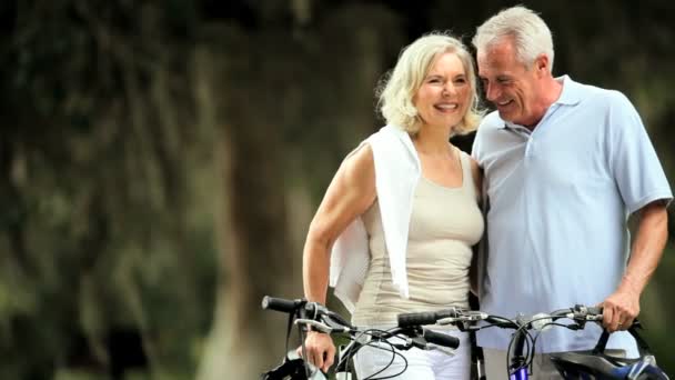 důchodci pár cyklistika pro fitness - Záběry, video