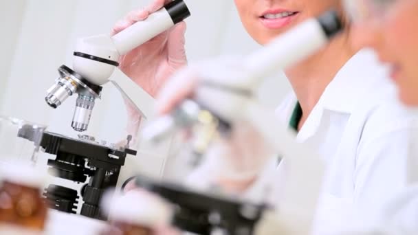 Pesquisadores médicos usando microscópios
 - Filmagem, Vídeo