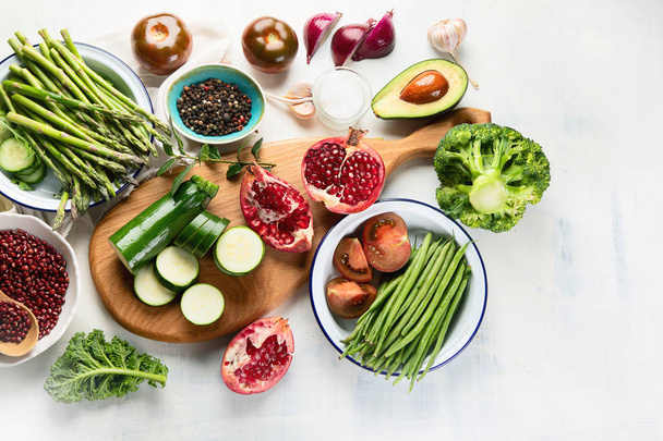 vista elevada de verduras veganas de temporada y granada en la mesa, concepto de alimentos saludables
 - Foto, Imagen