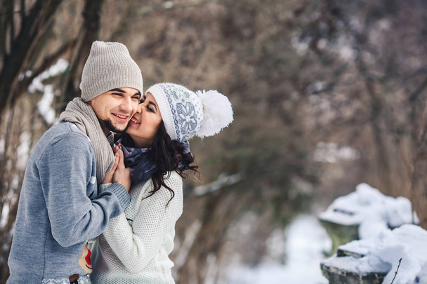 muž a dívka v svetry objímání v parku v zimě. Zimní procházka, odpočinek. - Fotografie, Obrázek