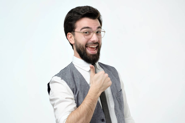 Yeah I like it concept. Pleased and satisfied male in glasses raising thumbs up and smiling broadly, - Photo, Image