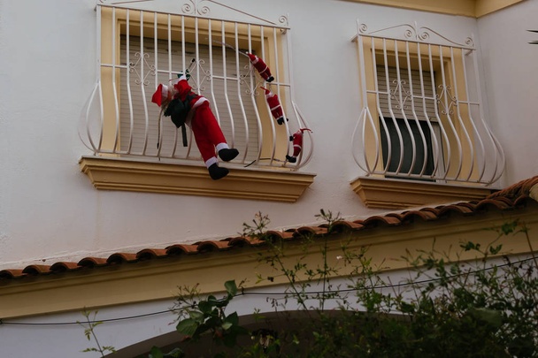 Spielzeug-Weihnachtsmann ragt ans Fenster - Foto, Bild