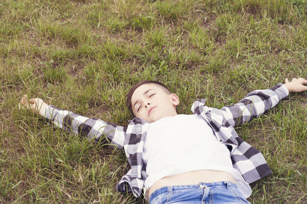Joyful boy relaxing on green grass - Zdjęcie, obraz