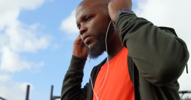 Man listening music in park. Man using smart watch 4k - Filmati, video
