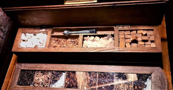 A group of rock sugar. Brown sugar cubes in wooden box . Various tea and various kind of sugar on wooden table - Photo, Image