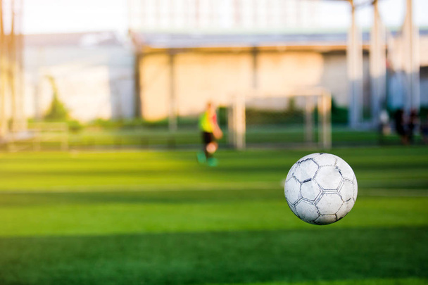 футбол відбивається з розмитим футбольним тренуванням на штучному газоні
. - Фото, зображення